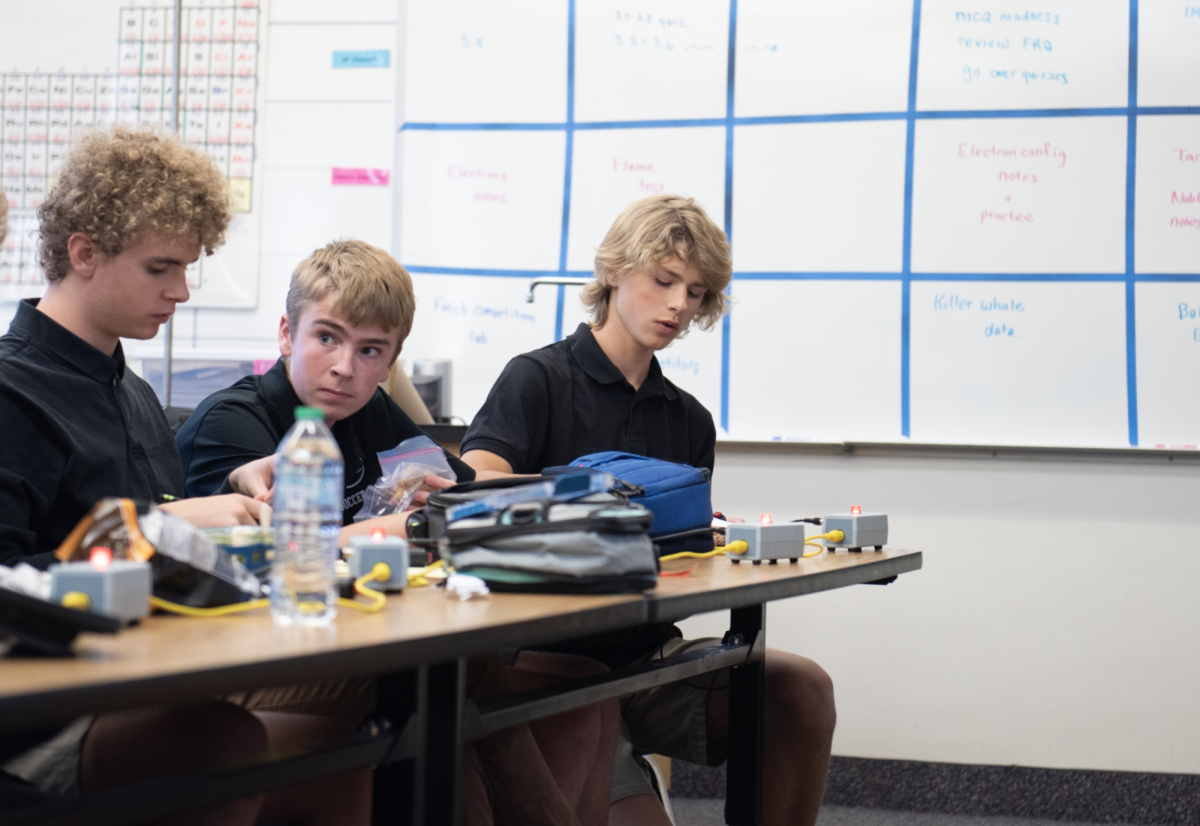 10.11.24 
(From L to R) Junior Alex Johnson, Freshman Christian Reck, and Freshman Gabe Starosta writing down and discussing the answer to a bonus question during science bowl practice. 